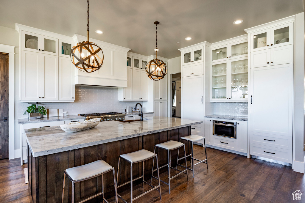 Kitchen featuring a chandelier, tasteful backsplash, white cabinetry, and recessed lighting