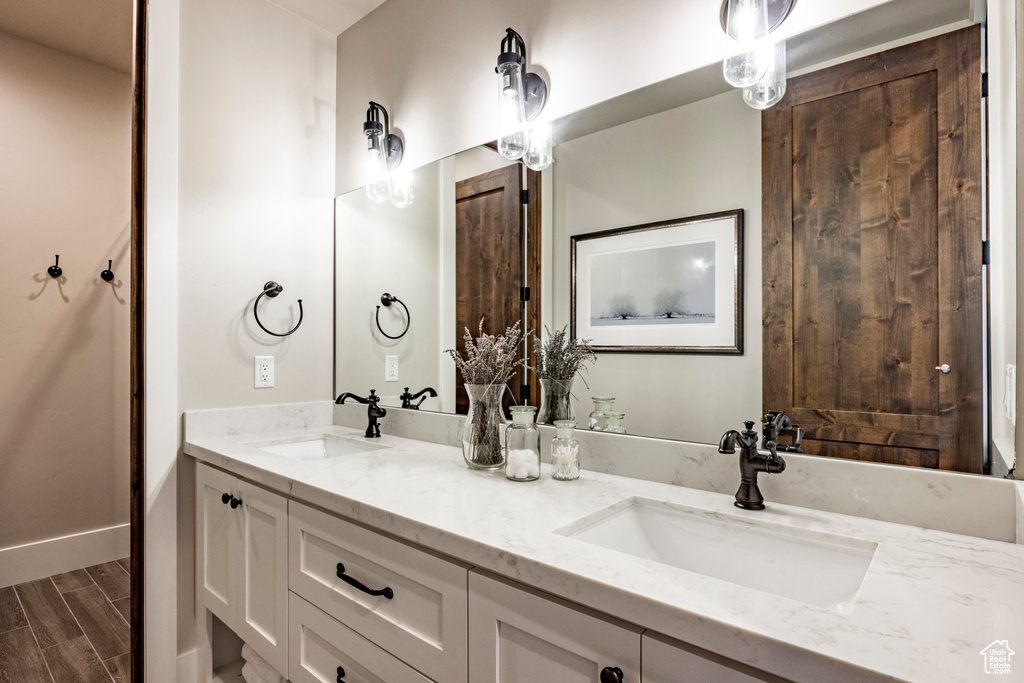 Bathroom with double vanity and wood finished floors