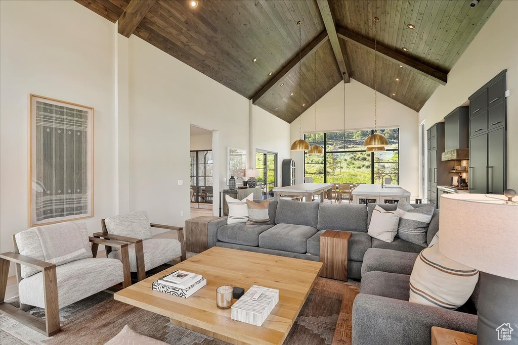 Living room featuring high vaulted ceiling, a wooden ceiling with exposed beams, wood finished floors, and recessed lighting