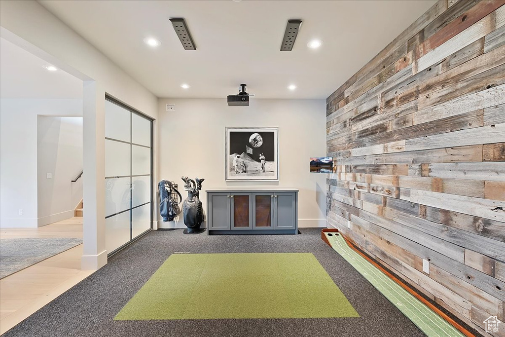 Playroom featuring recessed lighting, carpet, golf simulator, and wood walls