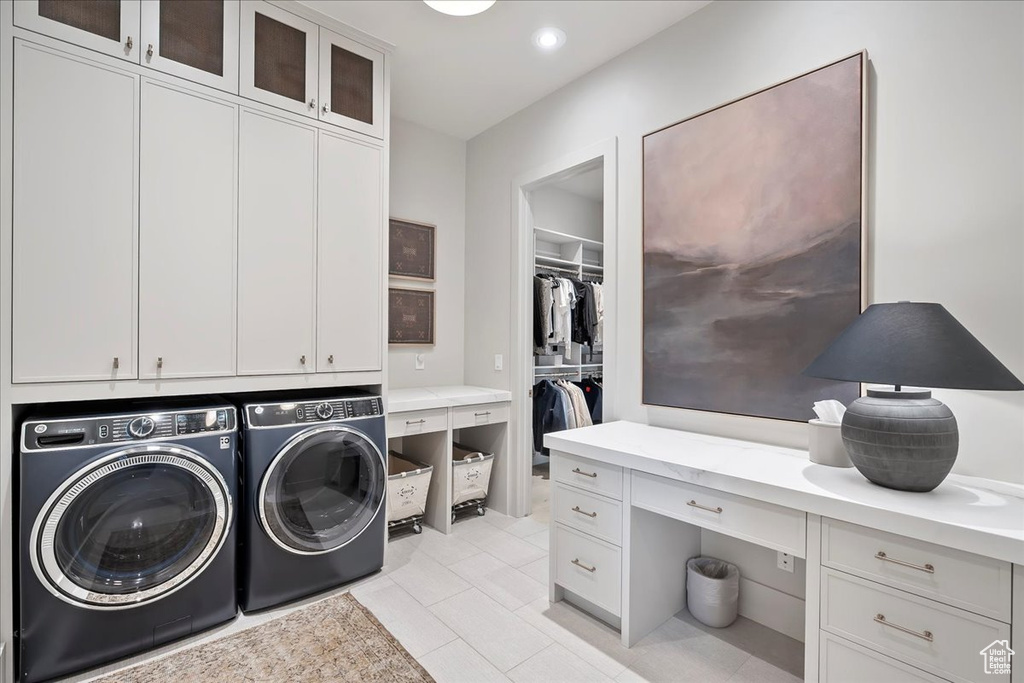 Laundry area with cabinet space, washing machine and dryer, recessed lighting, light tile patterned floors, and a desk