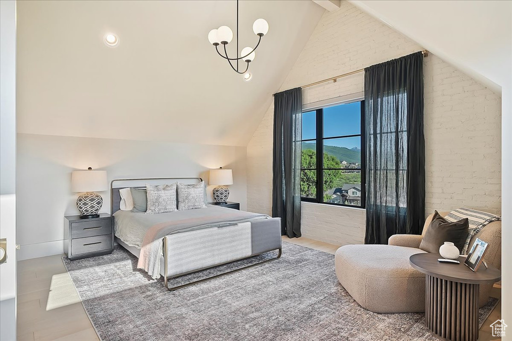 Bedroom featuring a chandelier and brick wall