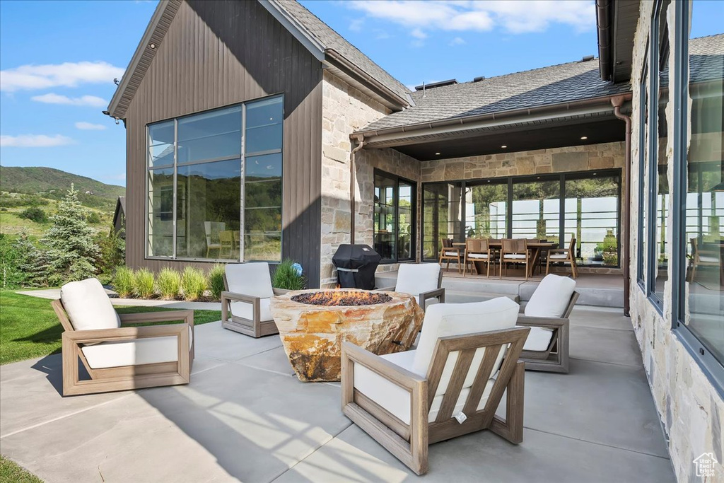 View of patio / terrace featuring grilling area, a mountain view, and an outdoor living space with a fire pit