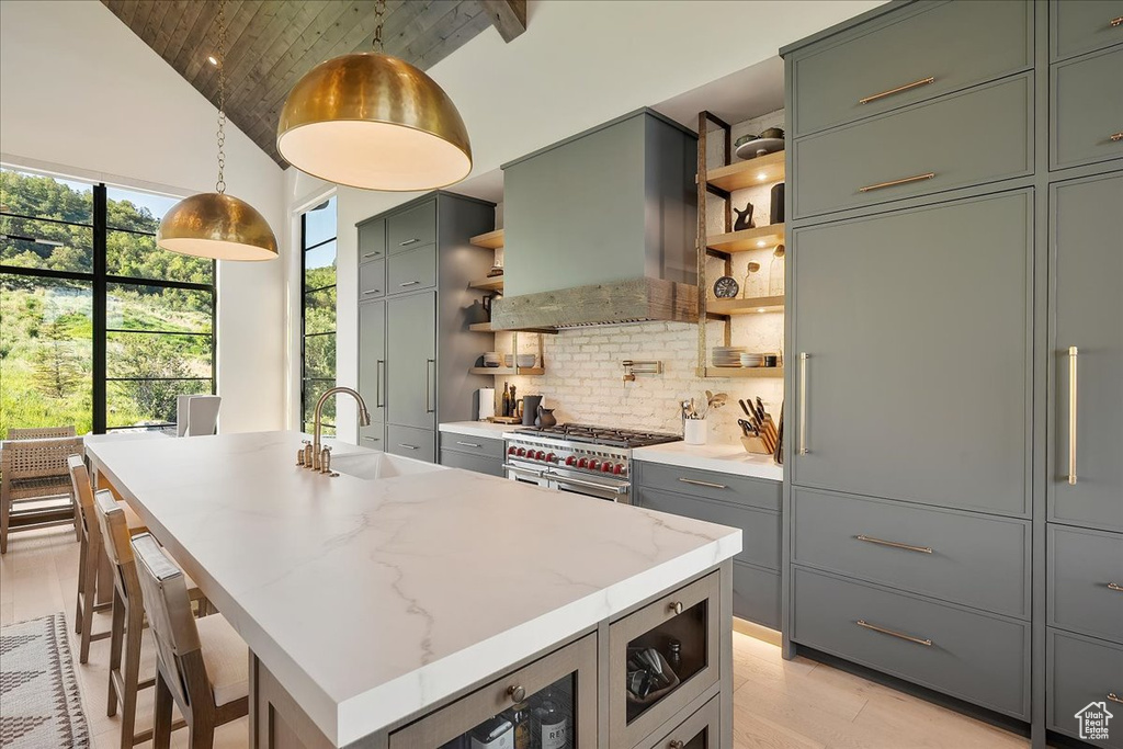 Kitchen with open shelves, wood ceiling, backsplash, wall chimney range hood, and high vaulted ceiling