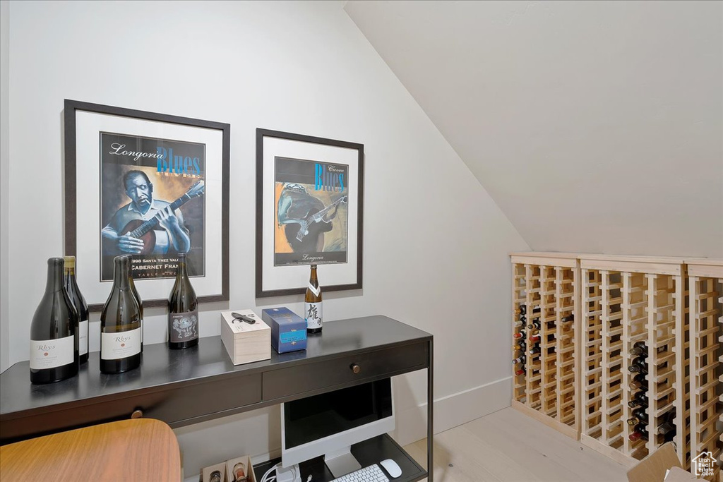 Wine room with lofted ceiling and baseboards
