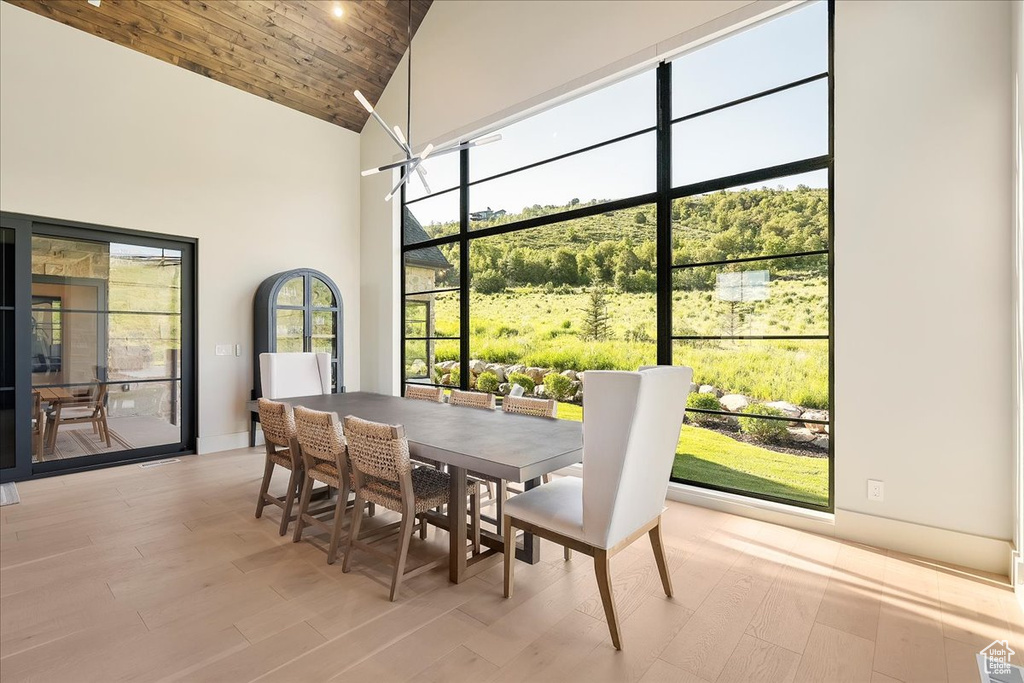 Dining area with high vaulted ceiling and light wood finished floors