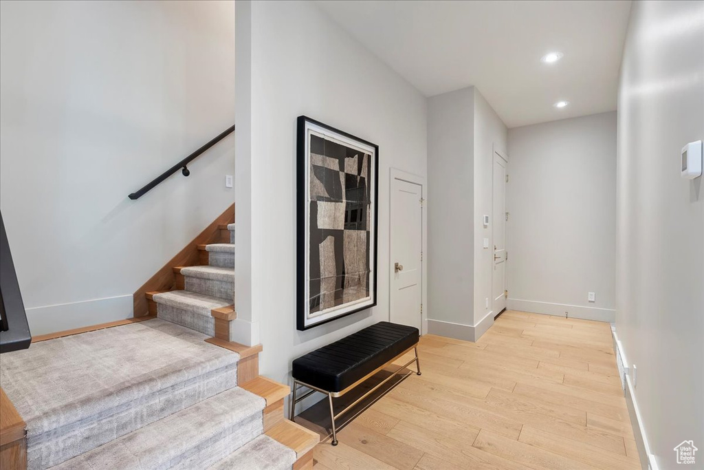 Corridor featuring light wood finished floors, recessed lighting, and stairway