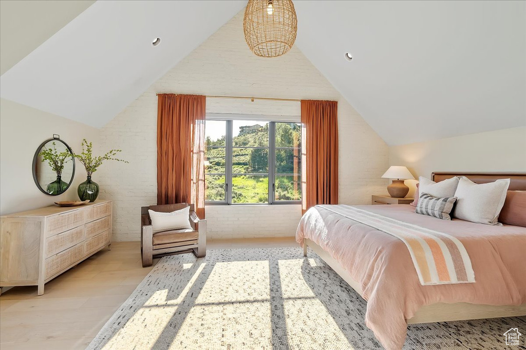 Bedroom with vaulted ceiling and light wood-style flooring