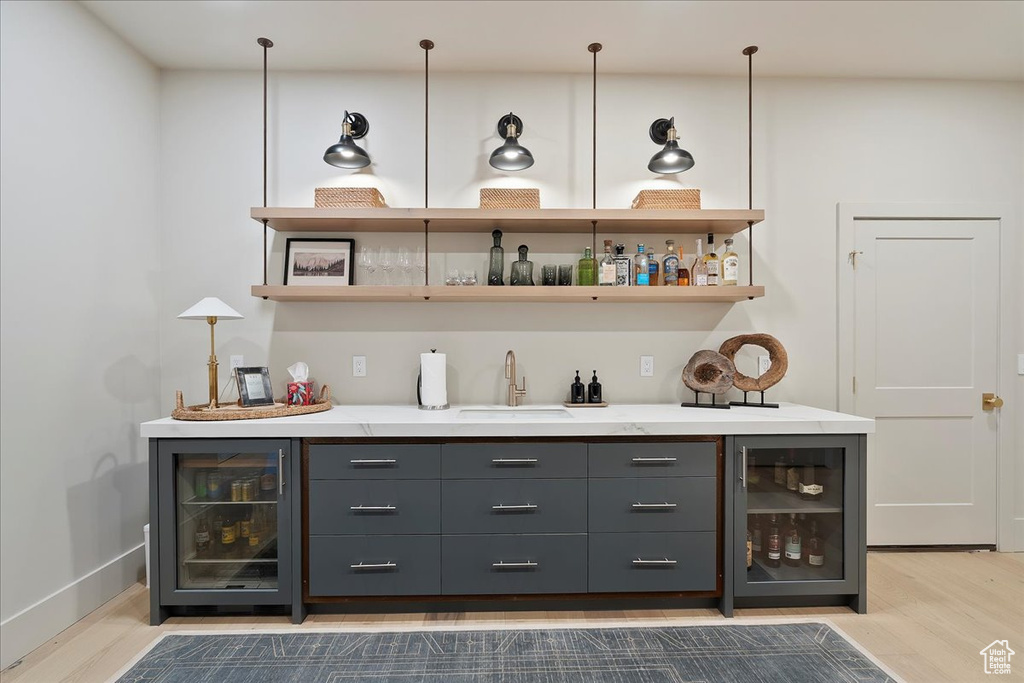 Indoor bar featuring wine cooler and wood finished floors