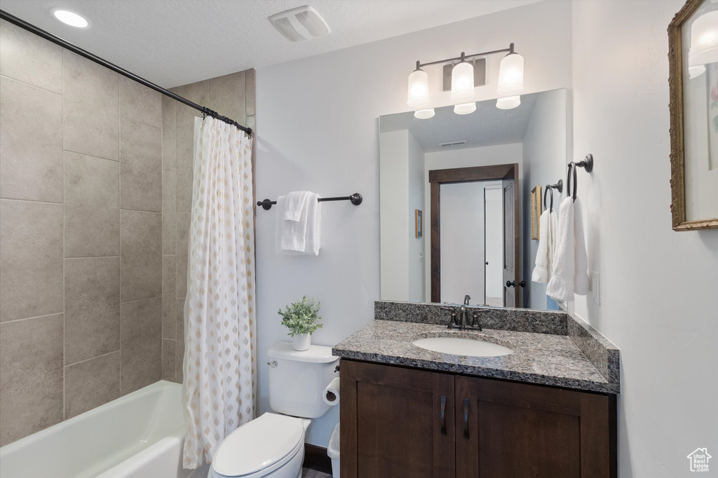 Bathroom with vanity and shower / tub combo with curtain