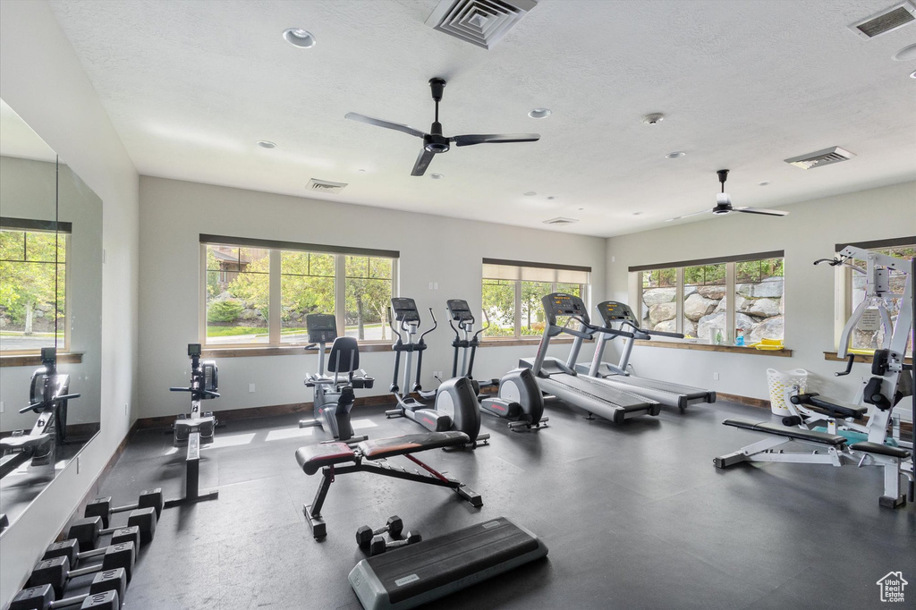 Exercise room featuring ceiling fan, a textured ceiling, and recessed lighting