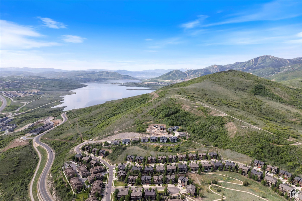 Aerial view of property and surrounding area featuring a water and mountain view and nearby suburban area