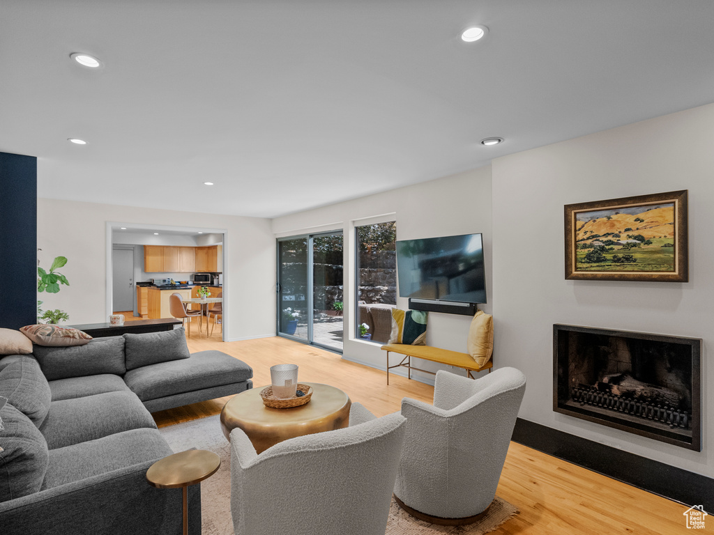 Living area with wood finished floors, recessed lighting, and a fireplace