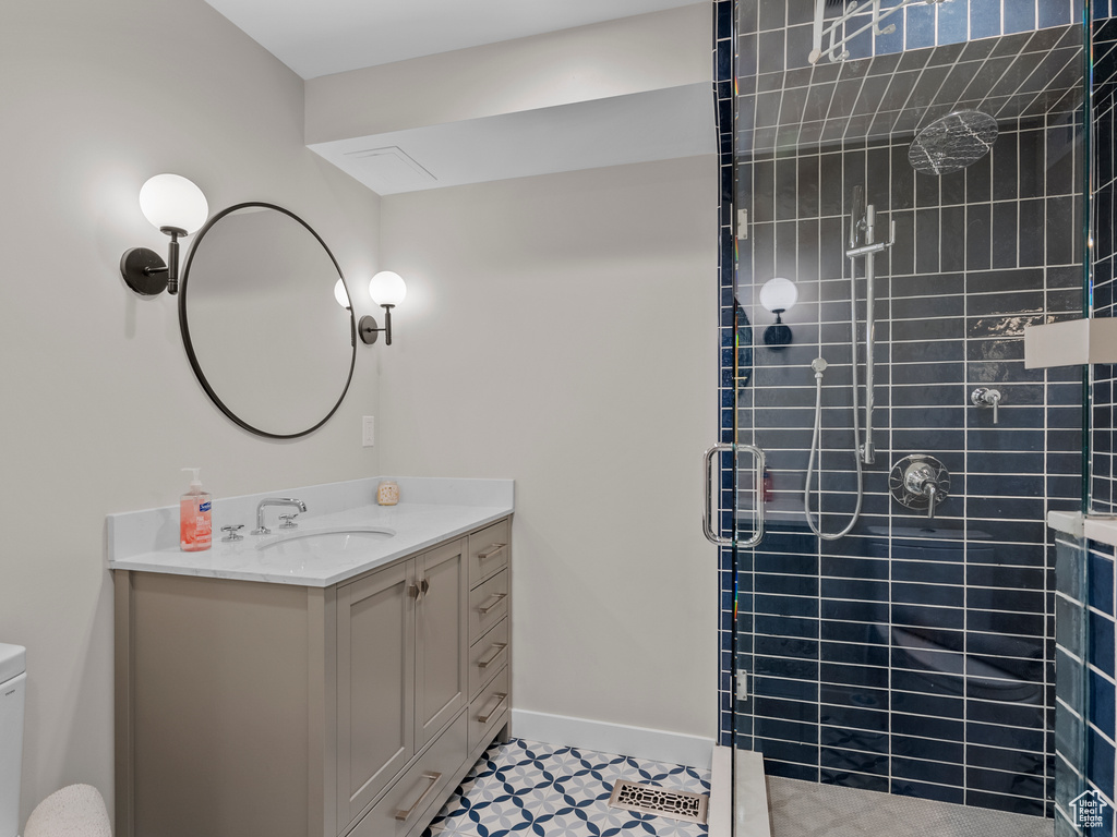 Full bathroom featuring a stall shower, vanity, and tile patterned floors