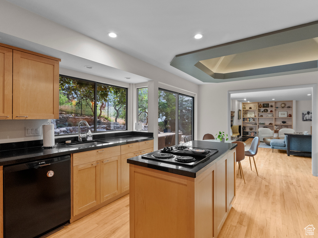 Kitchen with black appliances, light wood-style floors, recessed lighting, light brown cabinetry, and a center island