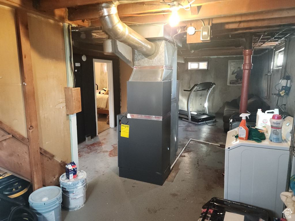 Below grade area with heating unit and washer / clothes dryer