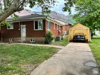 View of front of home with a front lawn, concrete driveway, and a carport