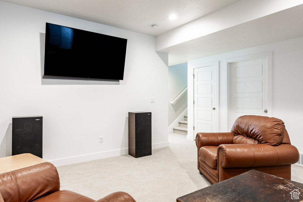 Living area with stairs and light carpet