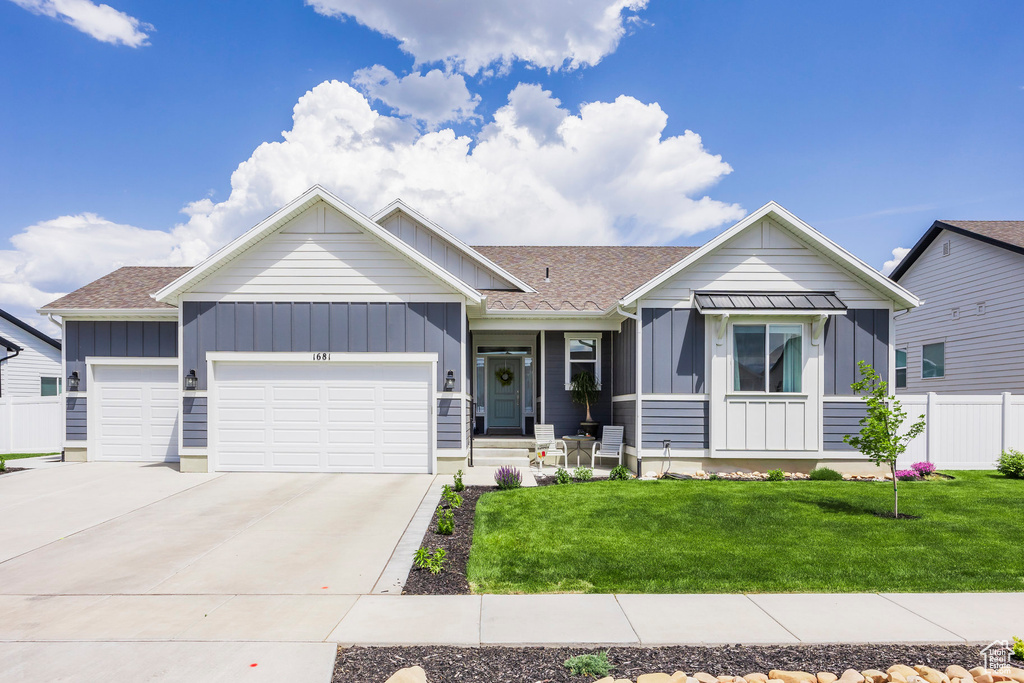 Ranch-style house featuring board and batten siding, an attached garage, driveway, and roof with shingles