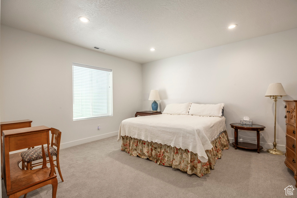 Carpeted bedroom featuring recessed lighting and a textured ceiling