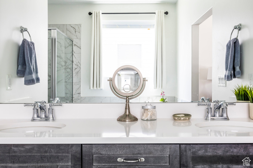 Full bath featuring double vanity and a stall shower
