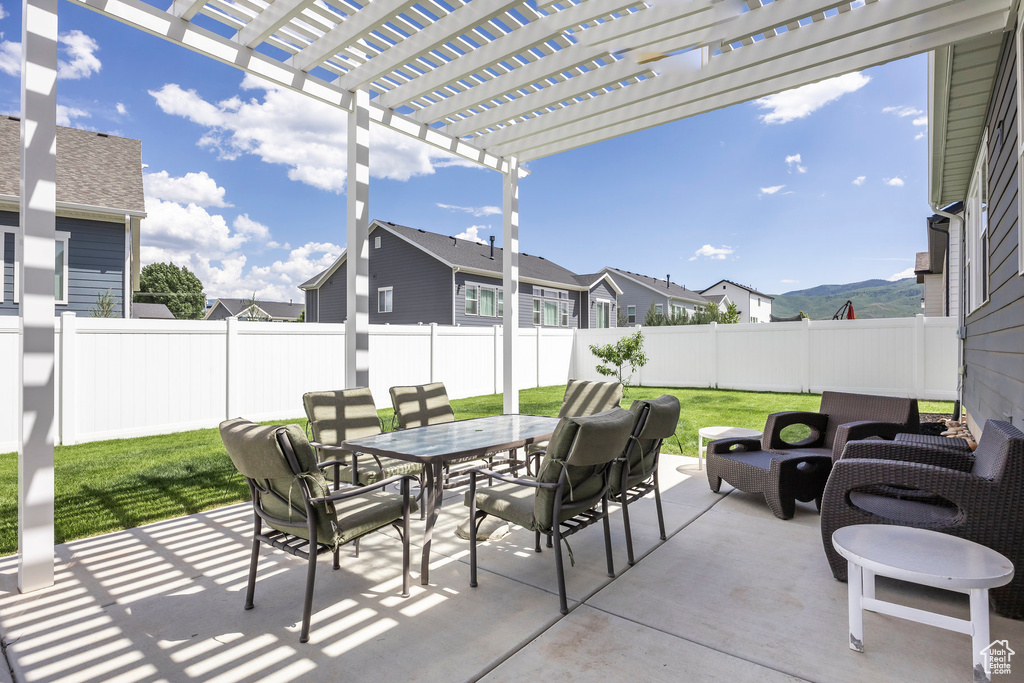 Fenced backyard with outdoor dining space, a pergola, a patio area, a residential view, and an outdoor hangout area