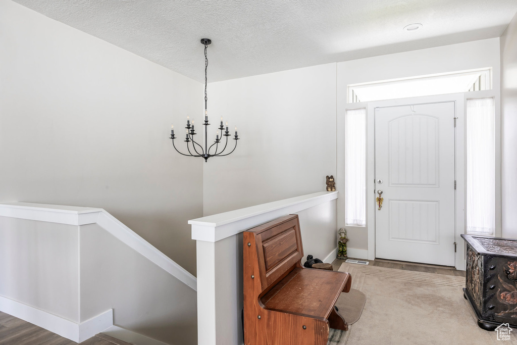 Foyer featuring a chandelier and baseboards