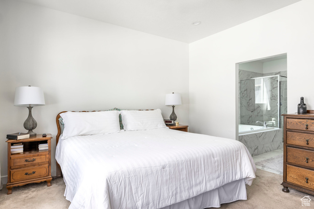 Bedroom featuring light carpet and ensuite bathroom