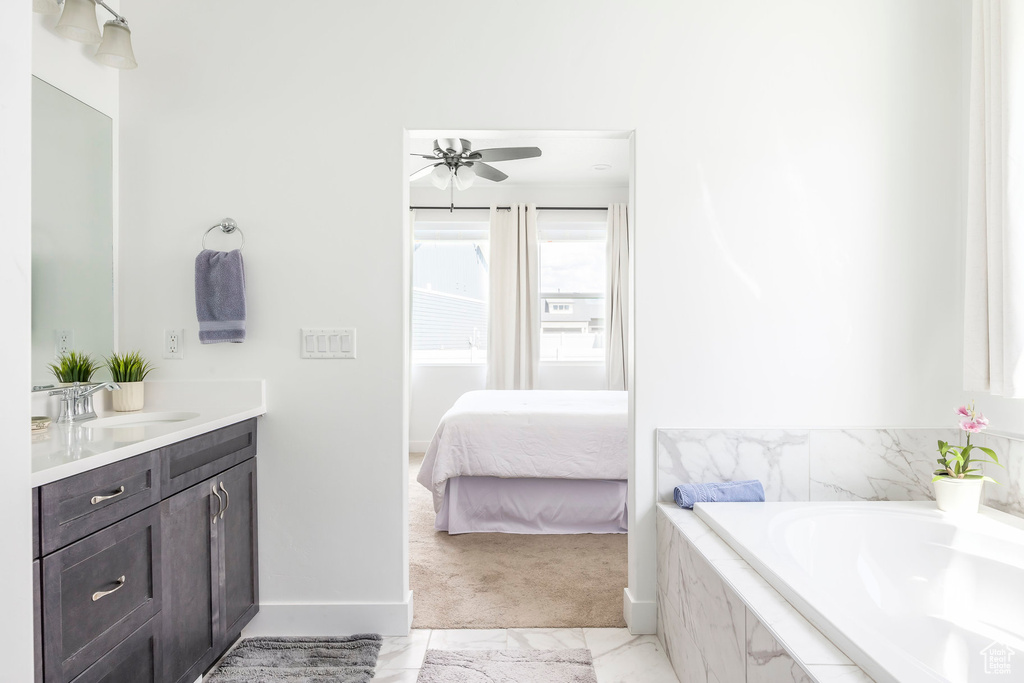 Full bathroom with vanity, a garden tub, a ceiling fan, and ensuite bath