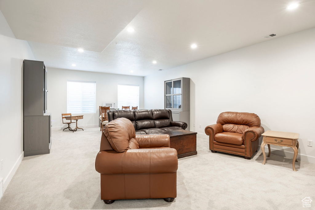 Living area with light colored carpet and recessed lighting