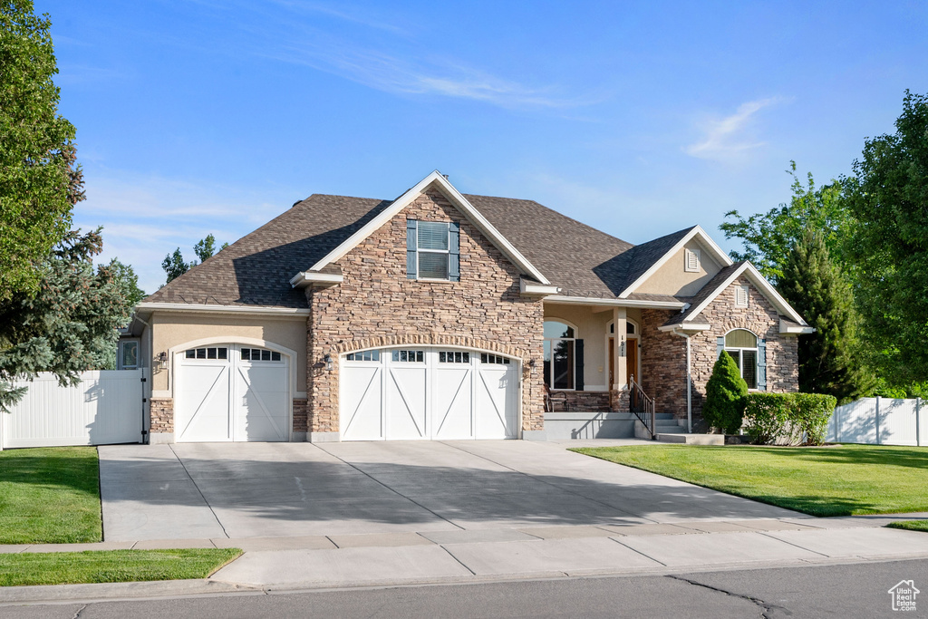 Craftsman inspired home with stucco siding, concrete driveway, stone siding, roof with shingles, and a garage