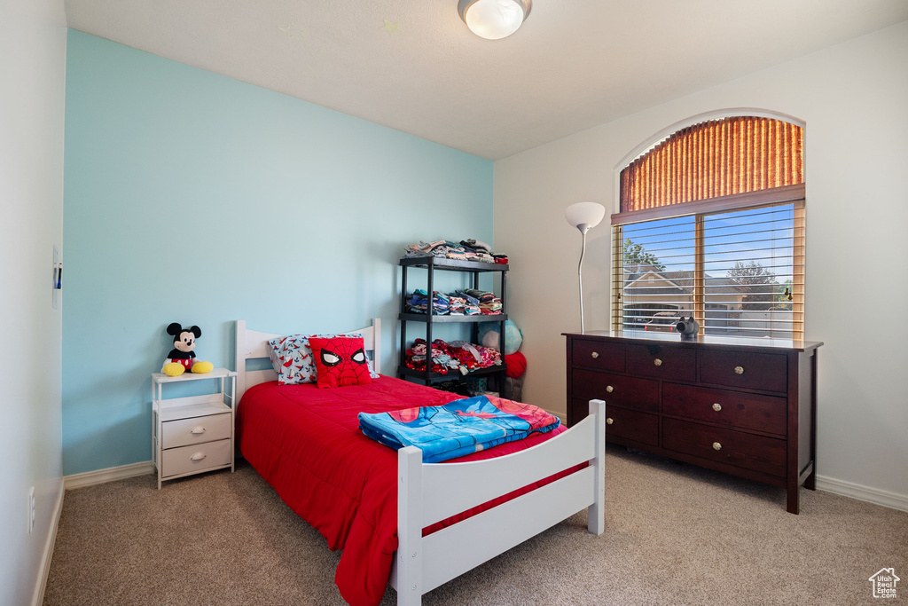 Bedroom with light colored carpet and baseboards