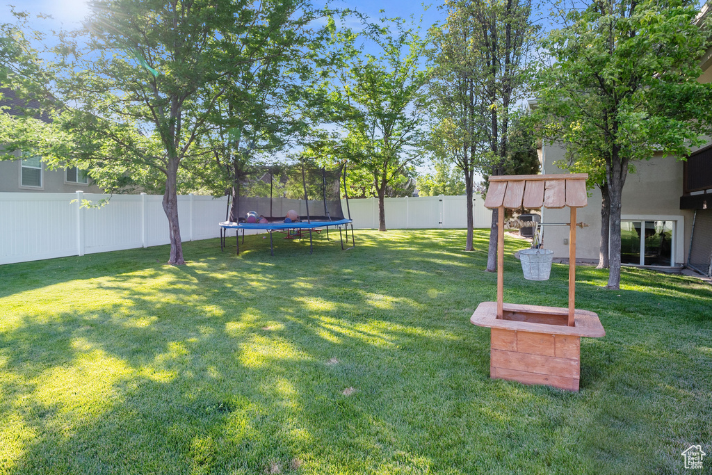Fenced backyard with a trampoline