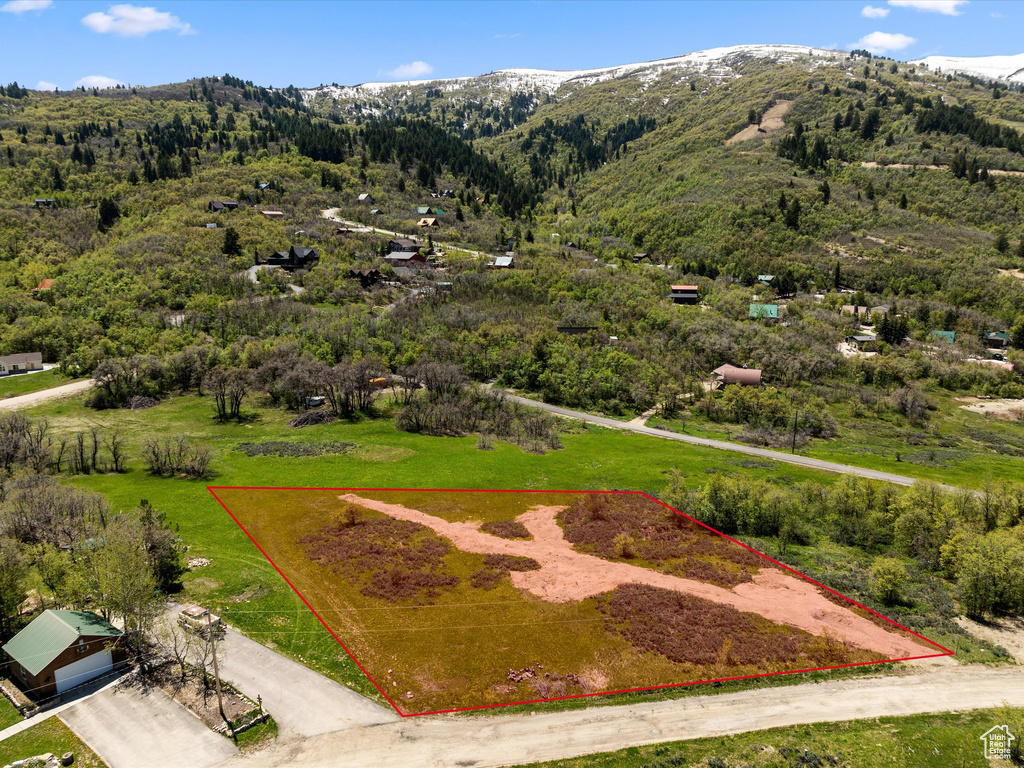 Aerial view of property and surrounding area featuring a mountain backdrop and property parcel outlined
