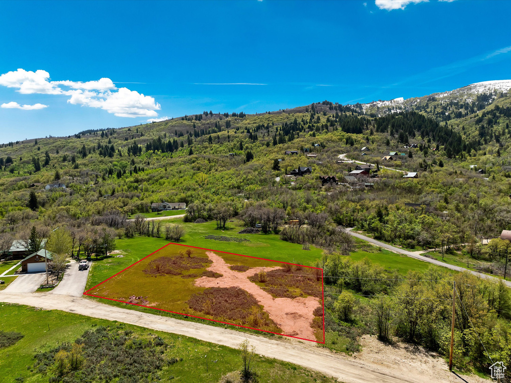 Aerial overview of property's location with a mountainous background and property boundaries highlighted