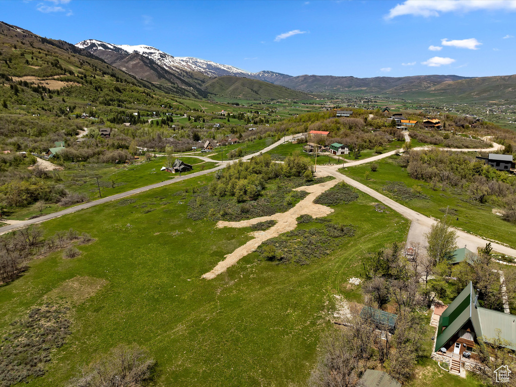 Aerial view of property and surrounding area with a mountainous background