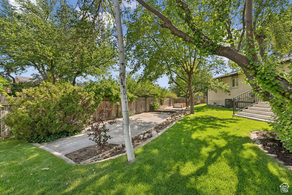 Fenced backyard featuring a patio and stairs
