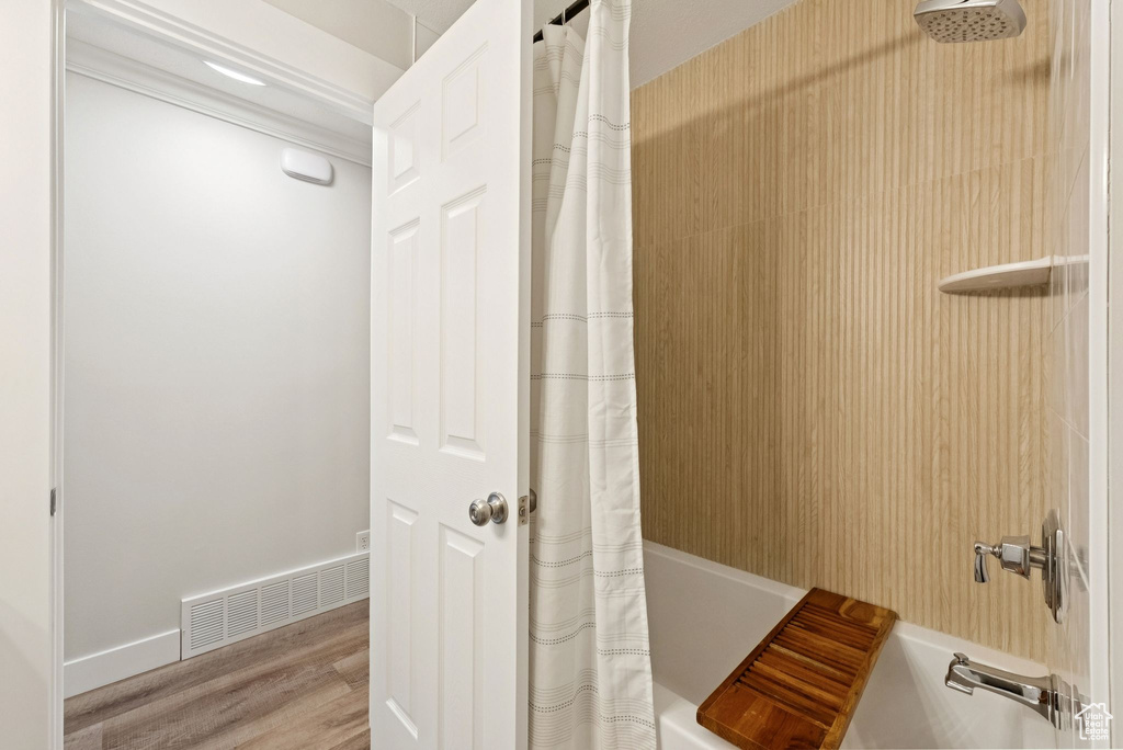 Bathroom featuring shower / tub combo and wood finished floors