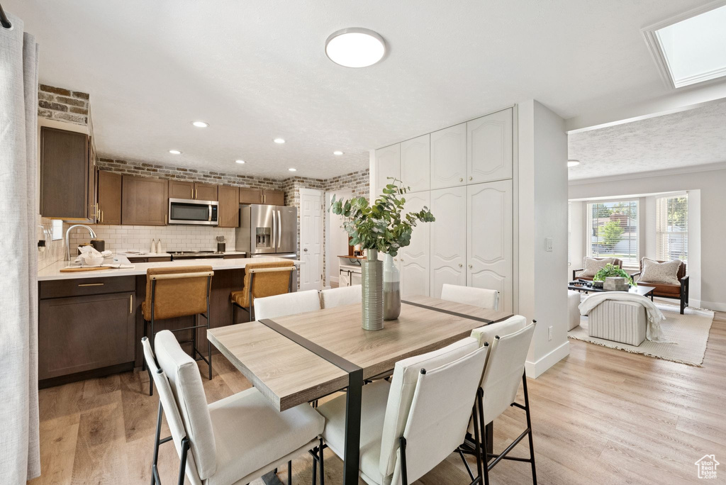 Dining room with light wood-type flooring and recessed lighting