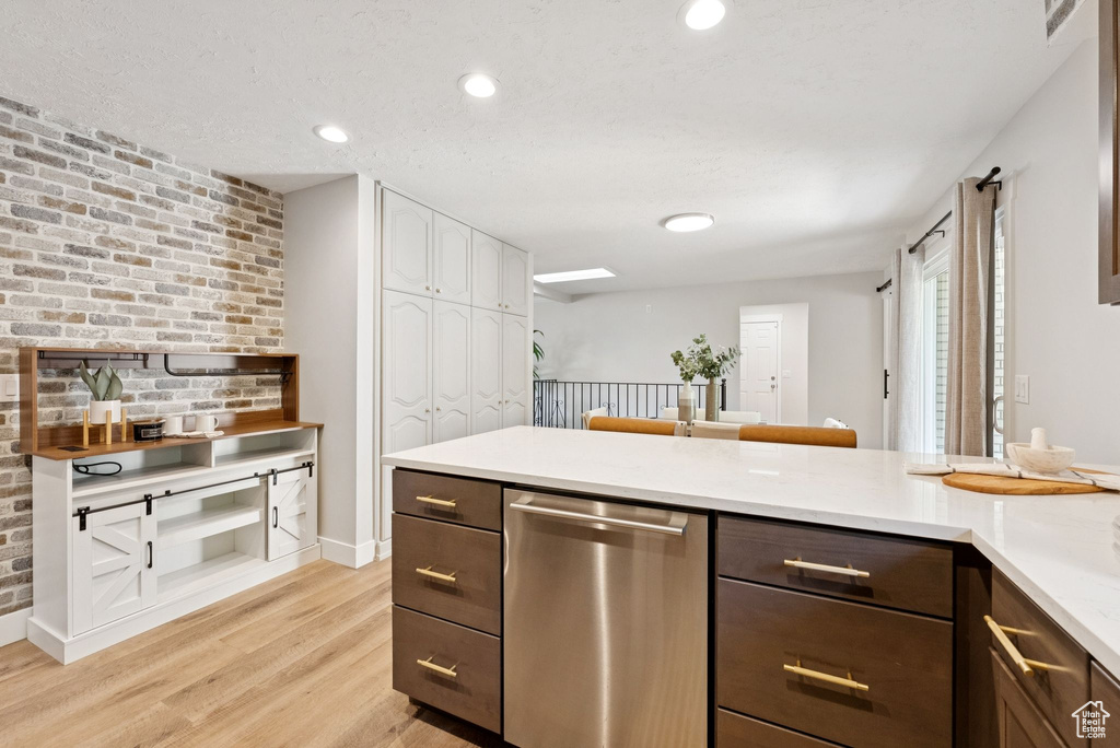 Kitchen with dishwasher, light wood-type flooring, light countertops, dark brown cabinets, and recessed lighting