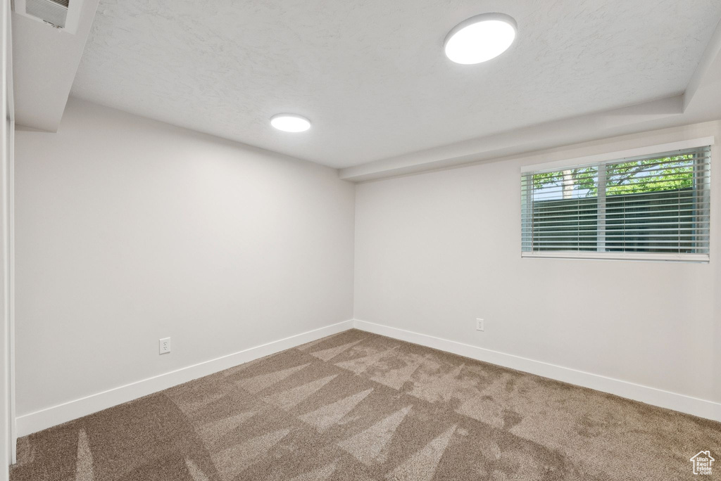 Carpeted spare room with a textured ceiling