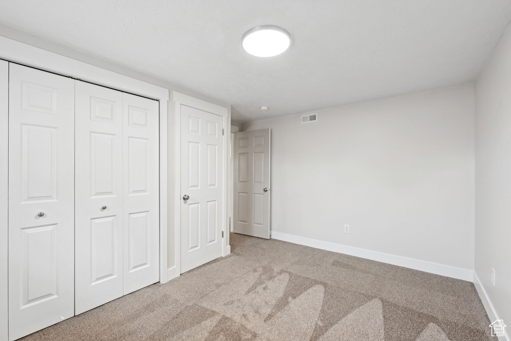 Unfurnished bedroom featuring carpet floors and a closet