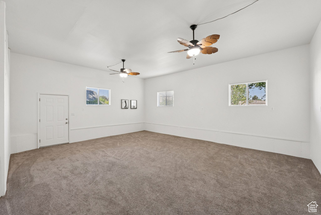 Carpeted spare room with a ceiling fan