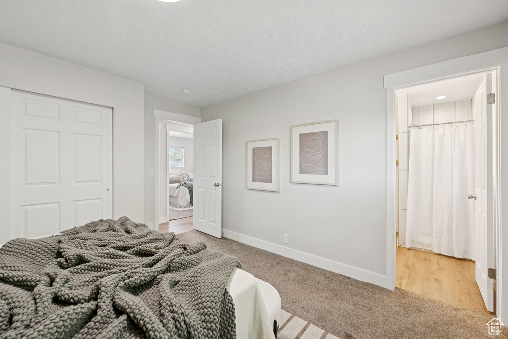 Bedroom with light colored carpet and a closet