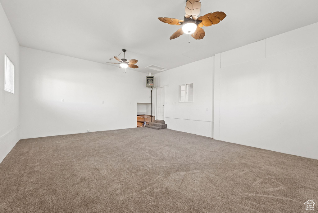 Spare room featuring ceiling fan, carpet floors, and attic access