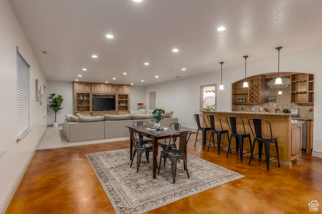 Dining room featuring concrete flooring and recessed lighting