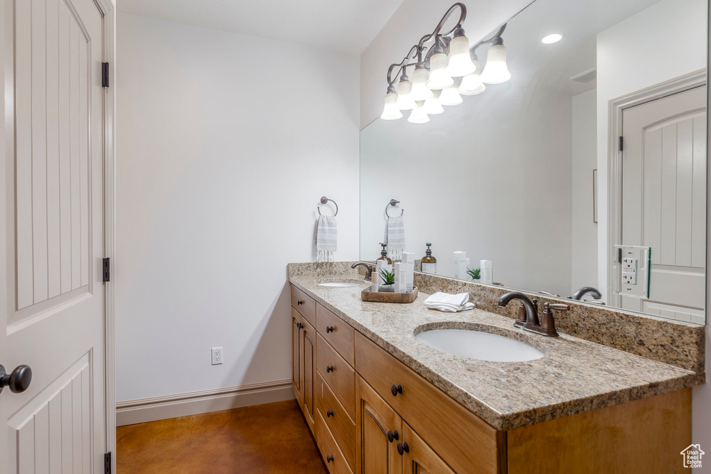 Full bath with double vanity and finished concrete floors