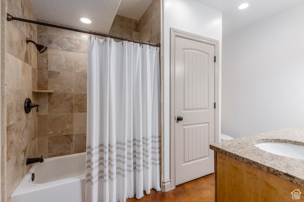Bathroom with vanity, shower / tub combo with curtain, and recessed lighting