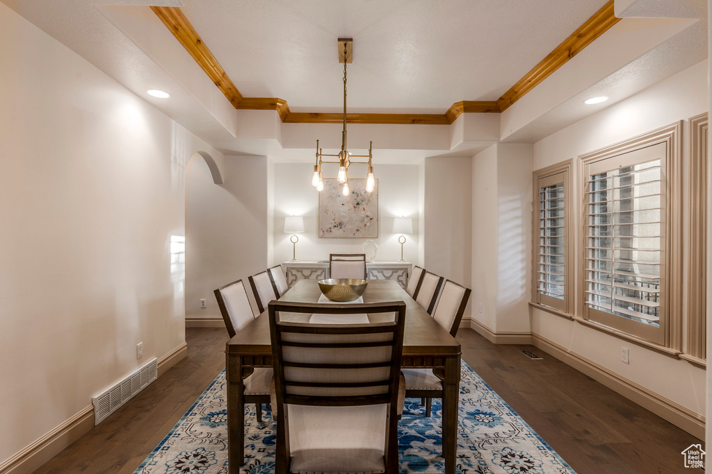 Dining area featuring dark wood finished floors, recessed lighting, and ornamental molding