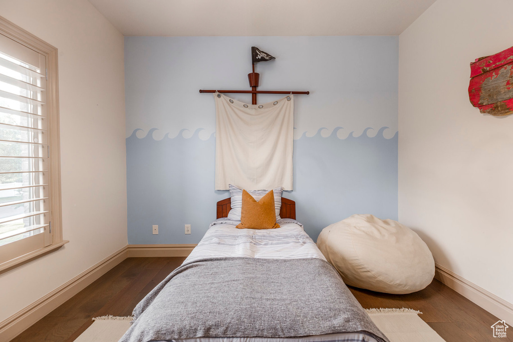 Bedroom with wood finished floors and baseboards